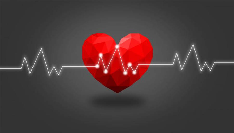 Heartbeat 桌布 壁紙 — 一個鮮紅色的低多邊形心臟在深灰色漸變背景上跳動，伴隨著一條發光的白色心跳線。