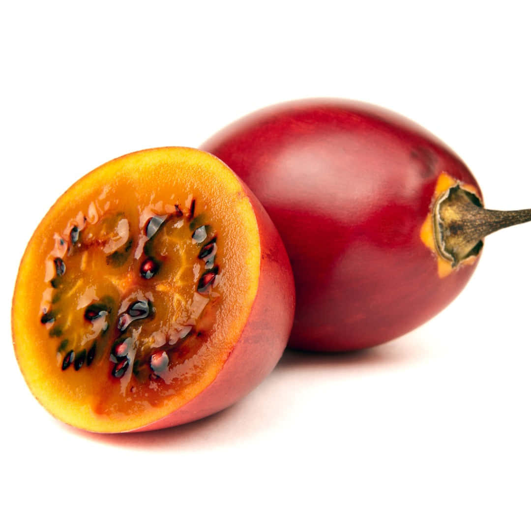 Fruit 桌布 壁紙 — 一個鮮紅色的茄子切開，露出多汁的橙色果肉和黑色種子，襯托在純白背景上。