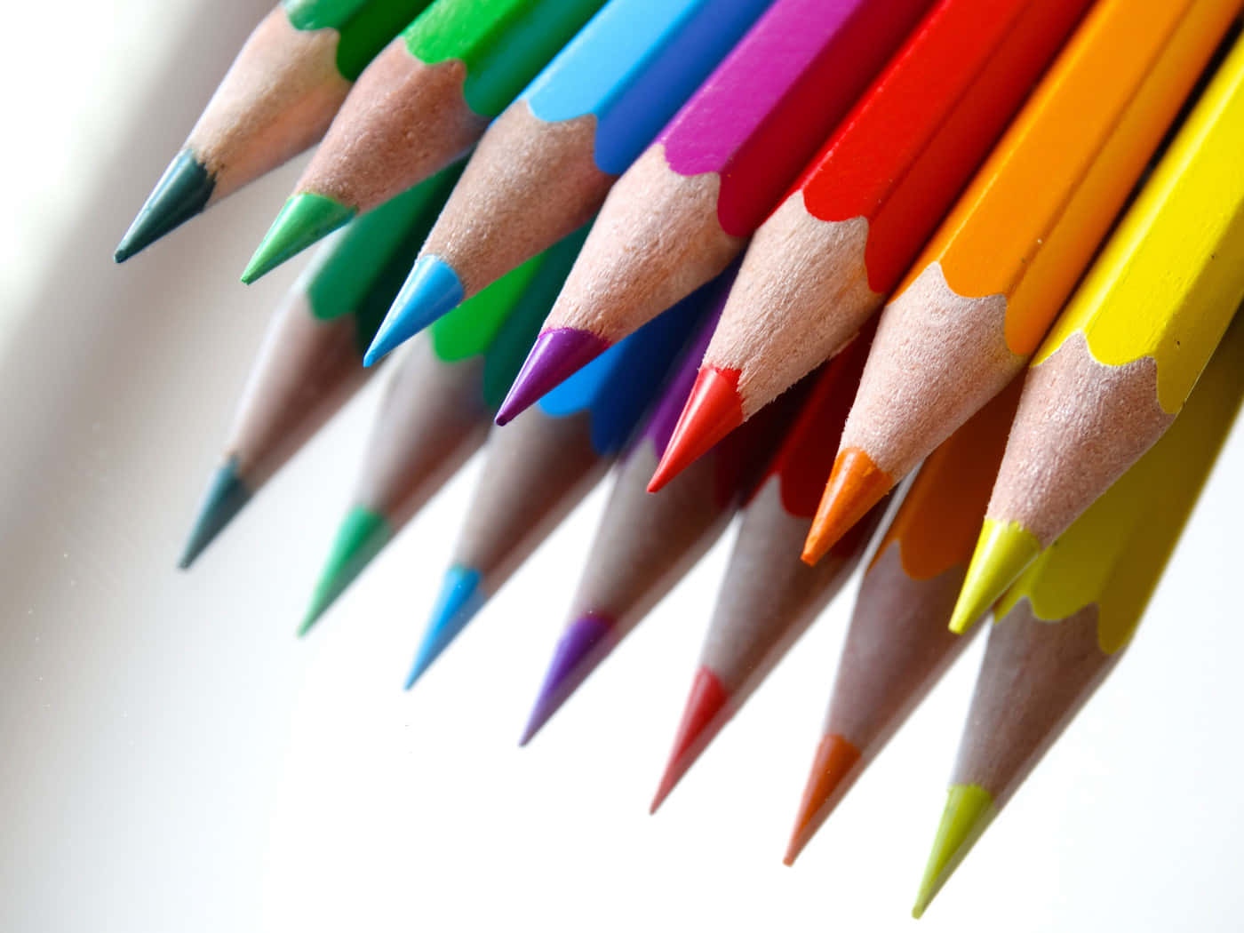 crayon 桌布 壁紙 — 一個鮮豔的特寫鏡頭，顯示削尖的彩色鉛筆在明亮的白色背景上以對角線彩虹圖案排列。