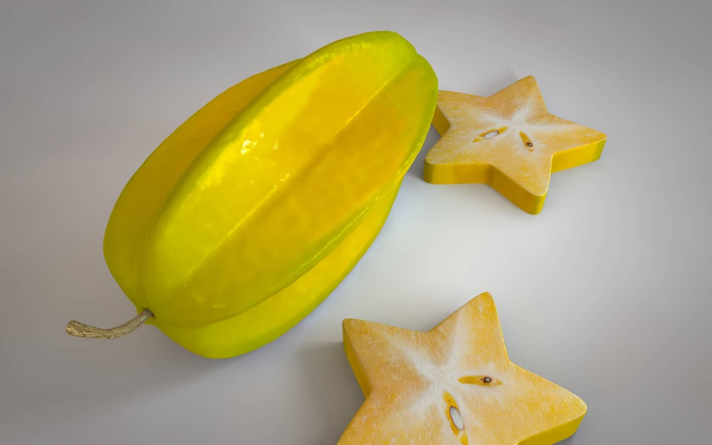 Fruit 桌布 壁紙 — 一個鮮黃色的楊桃和兩個星形切片放在純白色的表面上。