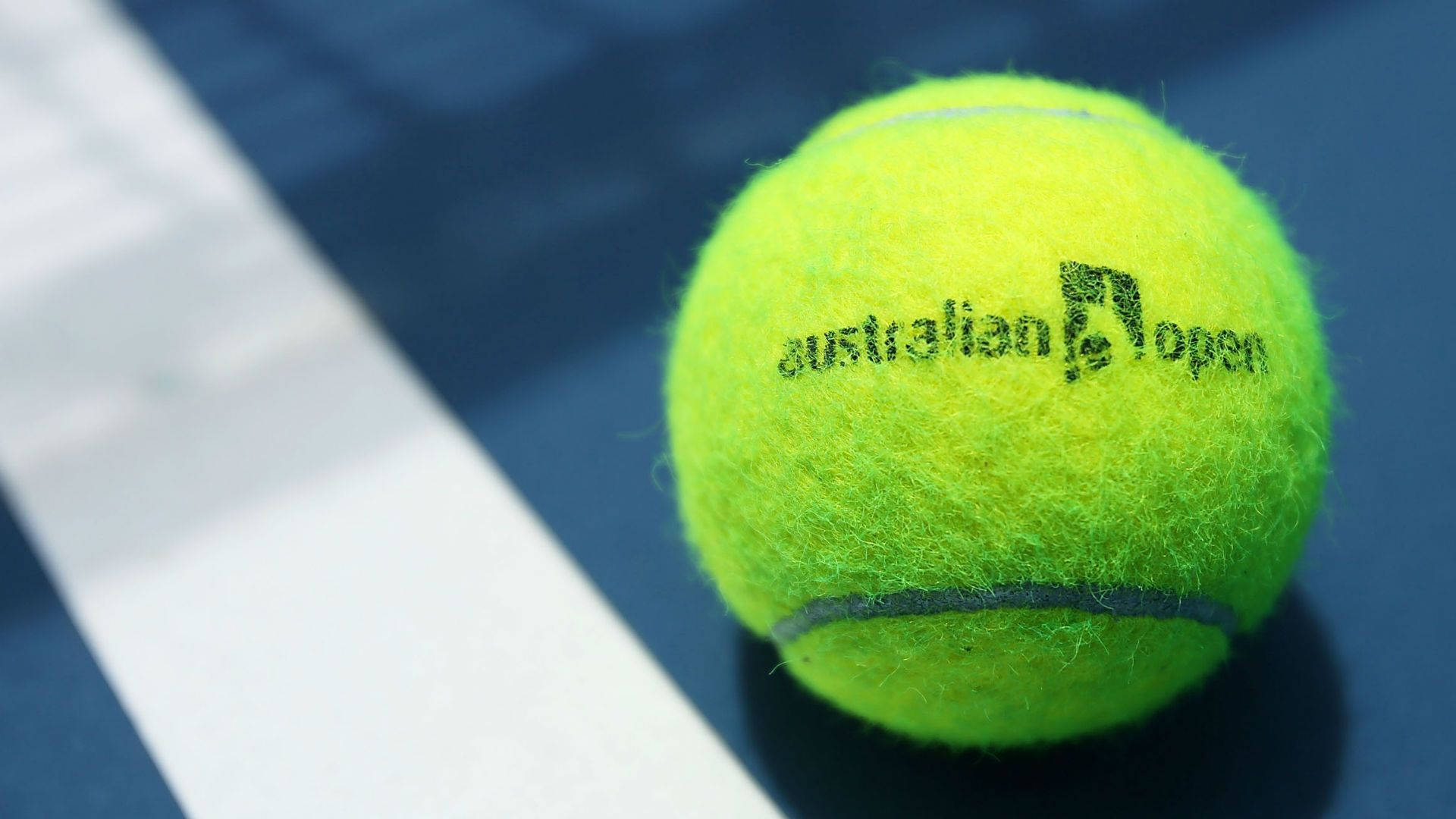 Australian Open 桌布 壁紙 — 一個鮮黃色的澳洲網球公開賽網球放在藍色球場上，帶有清晰的白色線條。