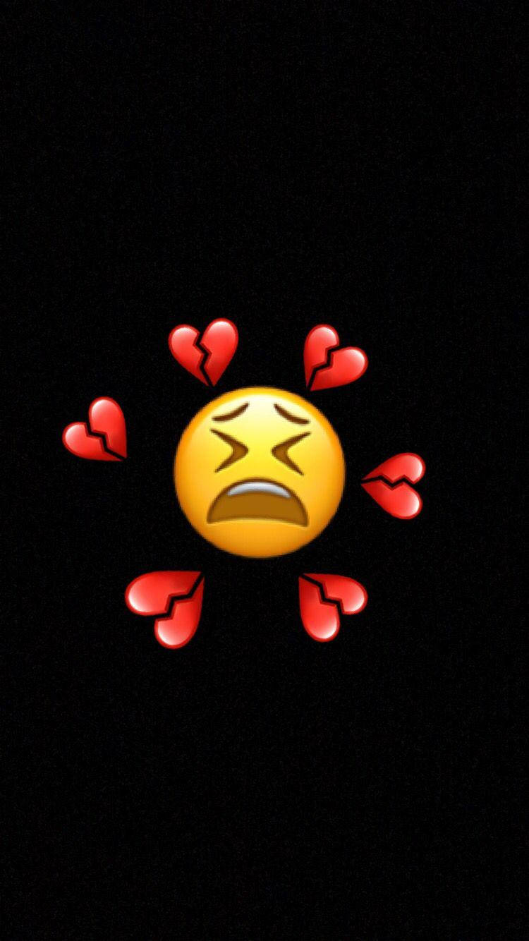 Broken Heart iPhone 桌布 壁紙 — 一個黃色哭泣的表情符號，被破碎的紅色愛心環繞，背景為黑色。