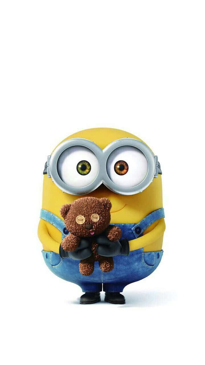 搞笑 桌布 壁紙 — 一個黃色的Minion戴著超大護目鏡，在純白背景前抱著一隻棕色的泰迪熊。