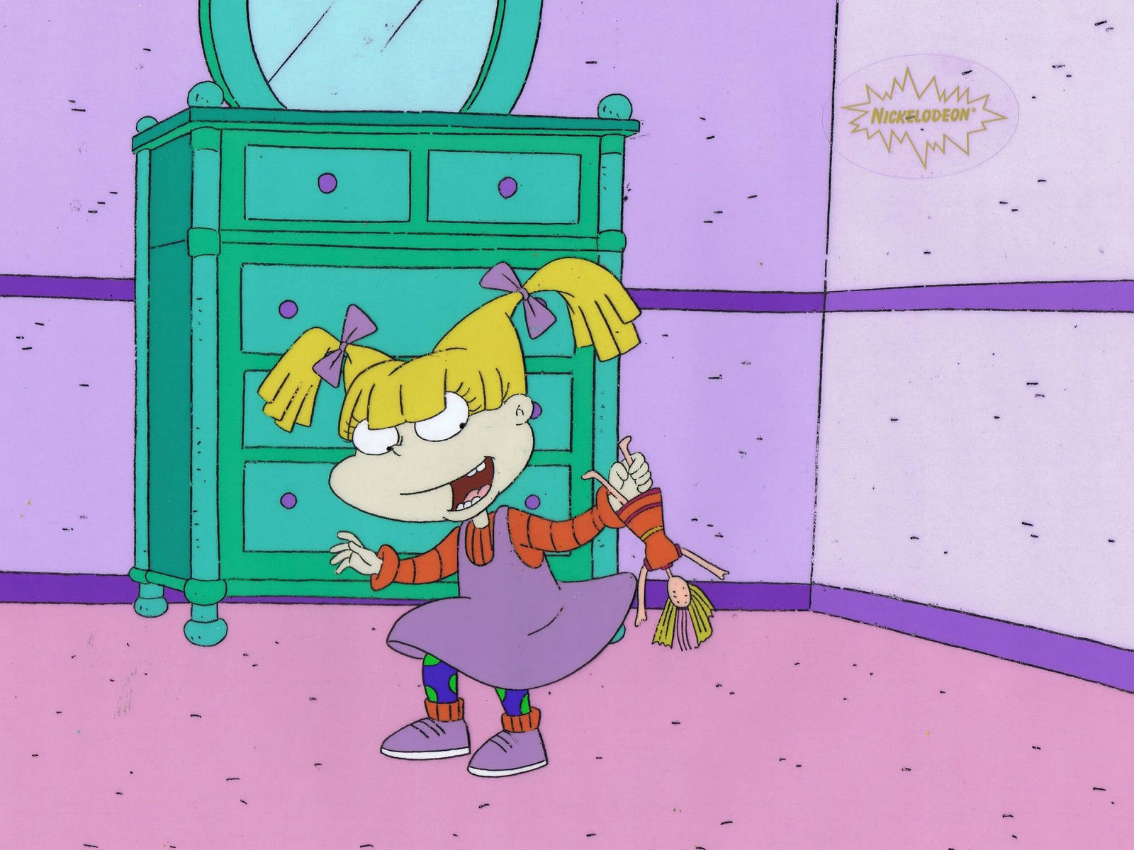 angelica pickles 桌布 壁紙 — 一個黃色雙馬尾、紫色連身裙的卡通女孩站在粉紅色房間裡，旁邊有一個綠色抽屜櫃，她抱著一個娃娃。