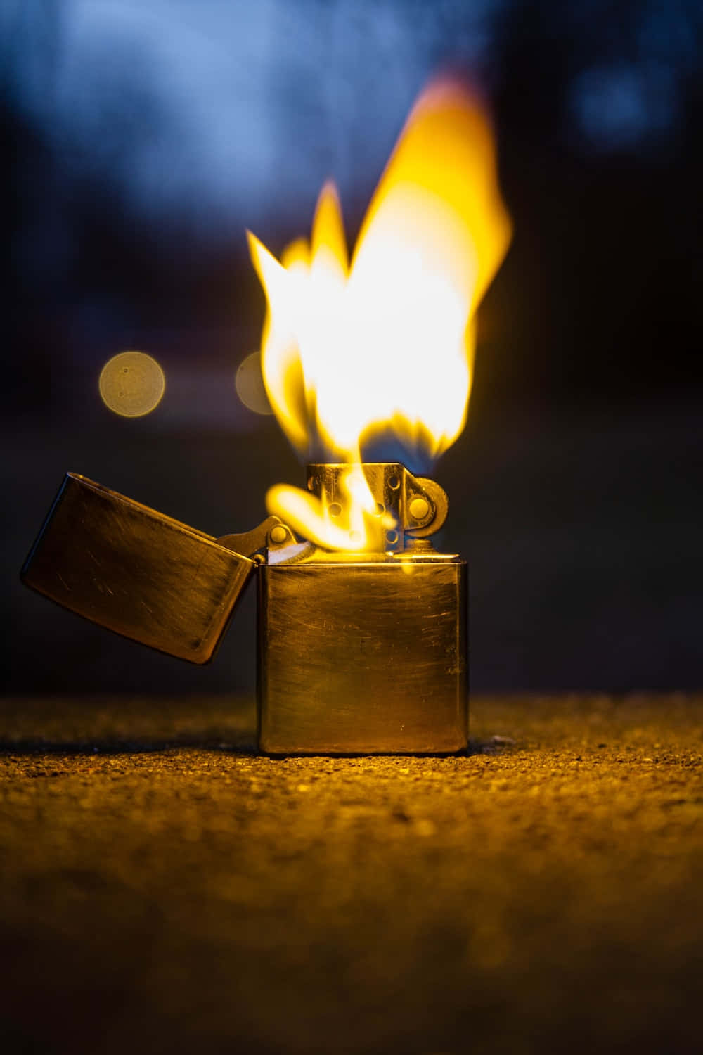 lighter 桌布 壁紙 — 一個黃銅打火機在黑暗模糊的背景上明亮地燃燒著鮮黃色的火焰。
