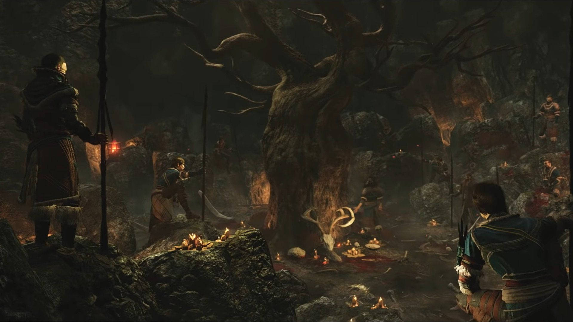 Greedfall 桌布 壁紙 — 一個黑暗奇幻場景，裝甲人物聚集在一個巨大的多節樹周圍，在岩石森林中搖曳的火把光下。
