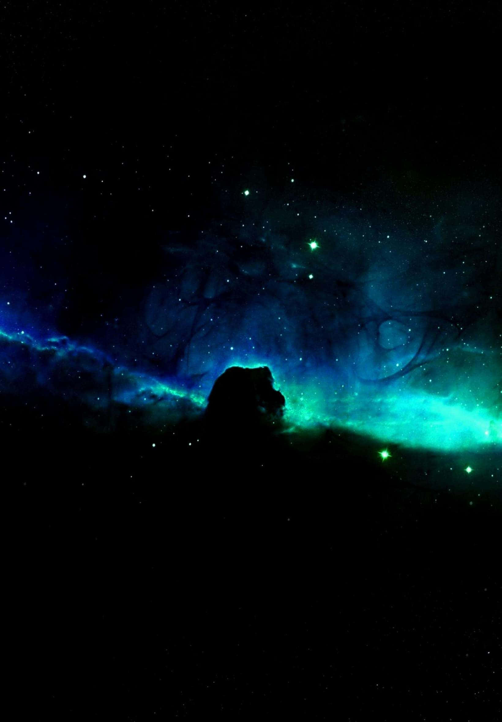 桌布 壁紙 — 一個黑暗的宇宙星雲剪影，在星空中散發著充滿活力的青綠色和藍色光芒。