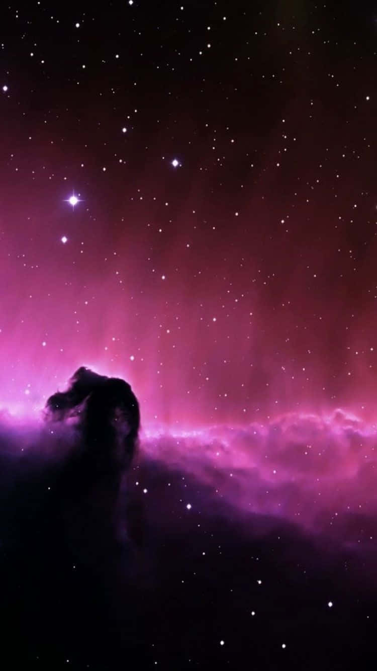 銀河 桌布 壁紙 — 一個黑暗的宇宙柱輪廓在充滿閃爍星星的鮮豔紫色星雲前升起。