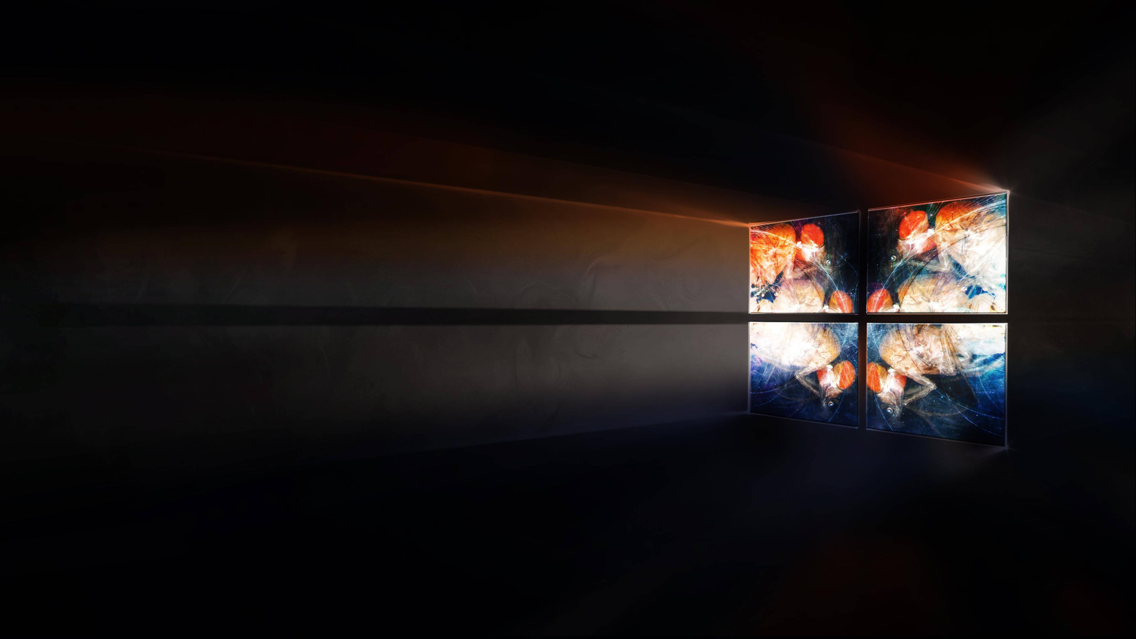 3840x2160 alienware 桌布 壁紙 — 一個黑暗的房間被一扇發光的窗戶照亮，窗戶顯示四個充滿活力的宇宙場景，有熾熱的星雲和旋轉的星系。
