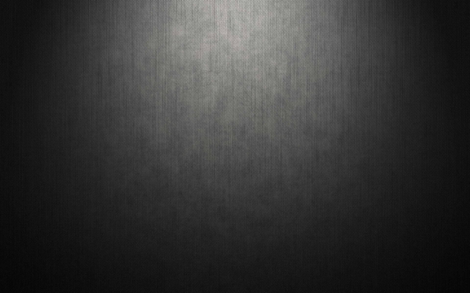 黑色 桌布 壁紙 — 一個黑暗的紋理表面，被柔和的聚光燈照亮，形成從明亮中心到深色陰影的漸變。
