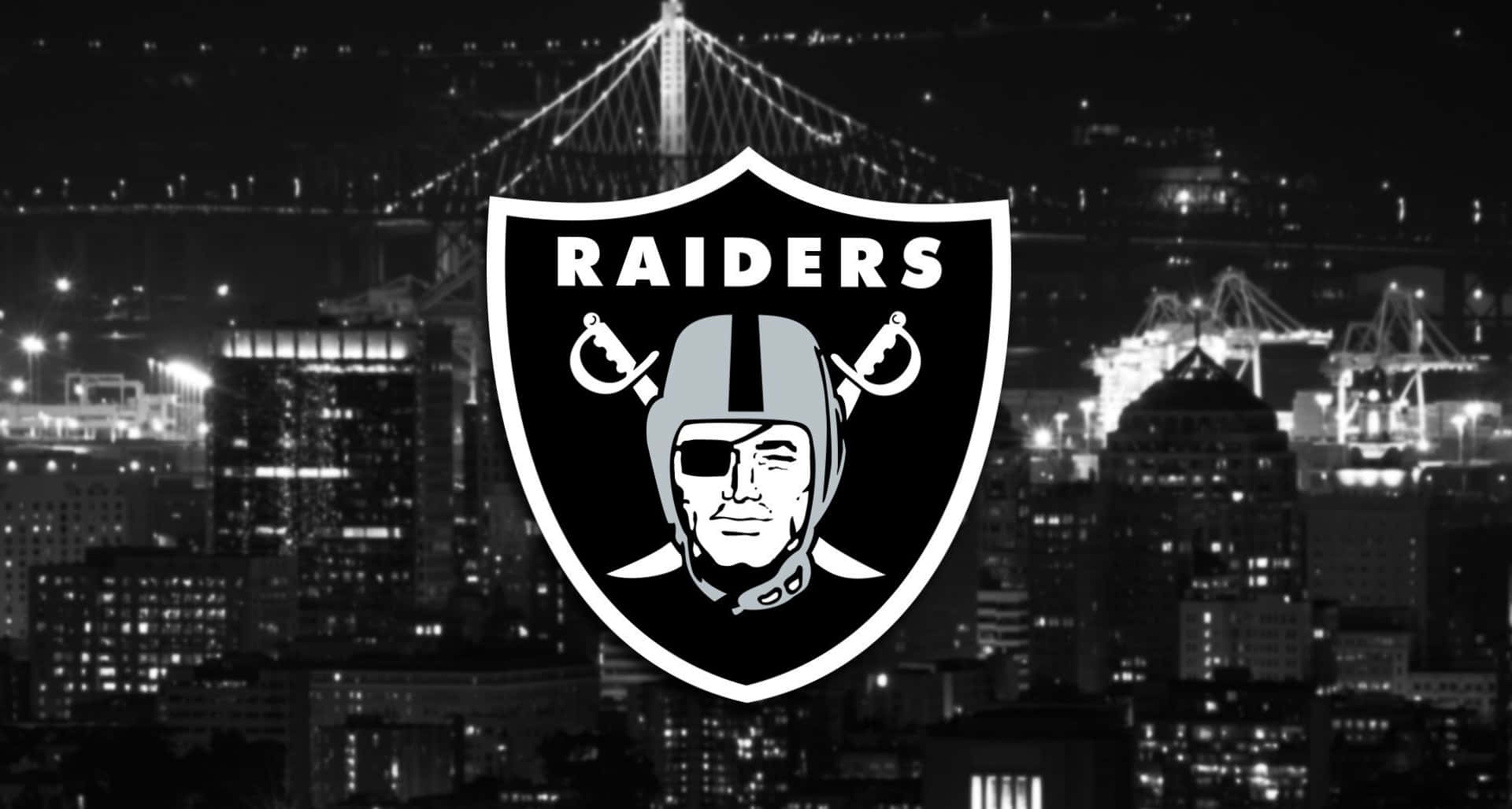 Raiders 標誌覆蓋在夜景城市上，有亮燈的橋樑和起重機。 — 突襲者 GIF 壁紙