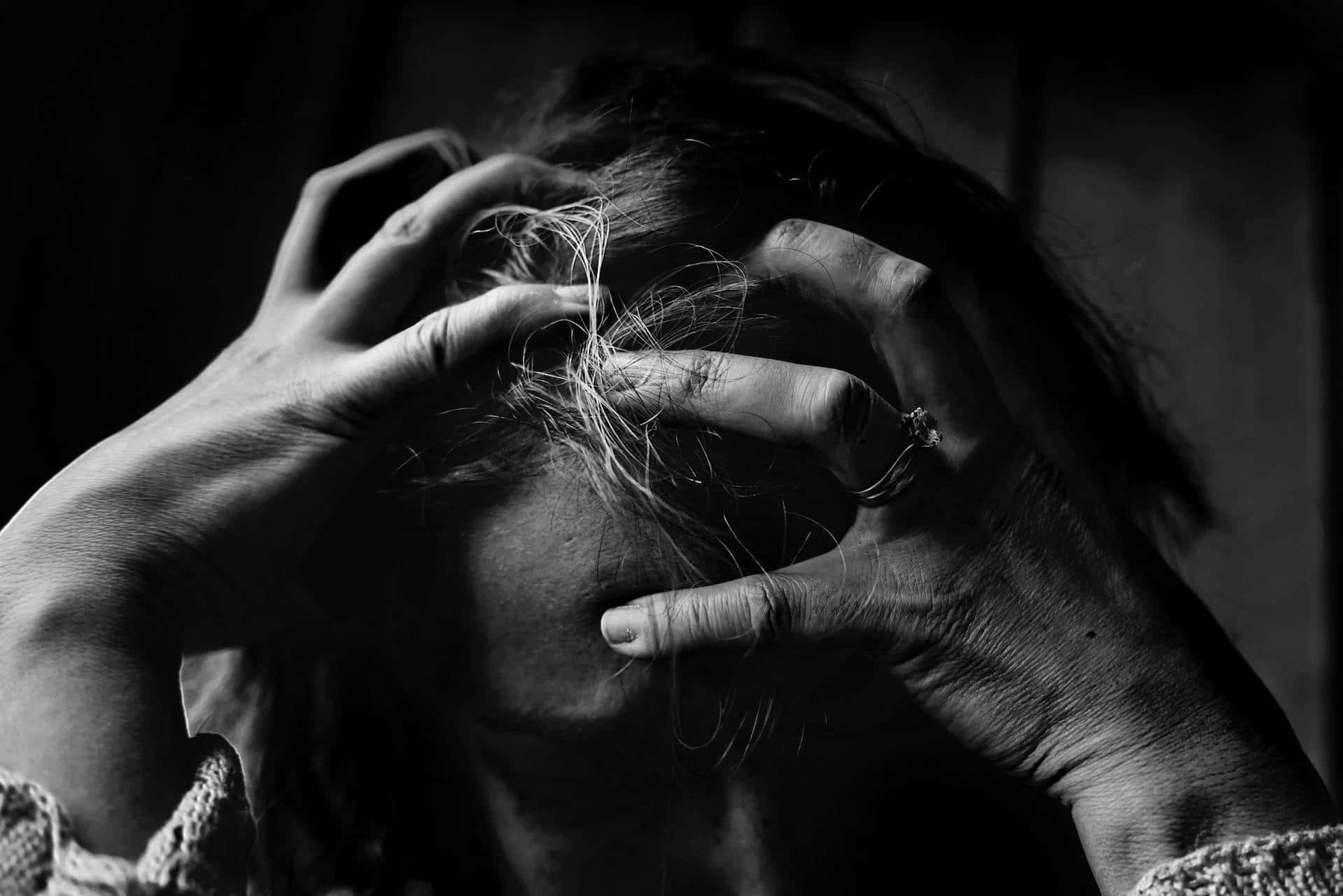 Dark Emotional 桌布 壁紙 — 一個黑白人物在黑暗背景下痛苦地雙手抓著頭髮抱住頭。
