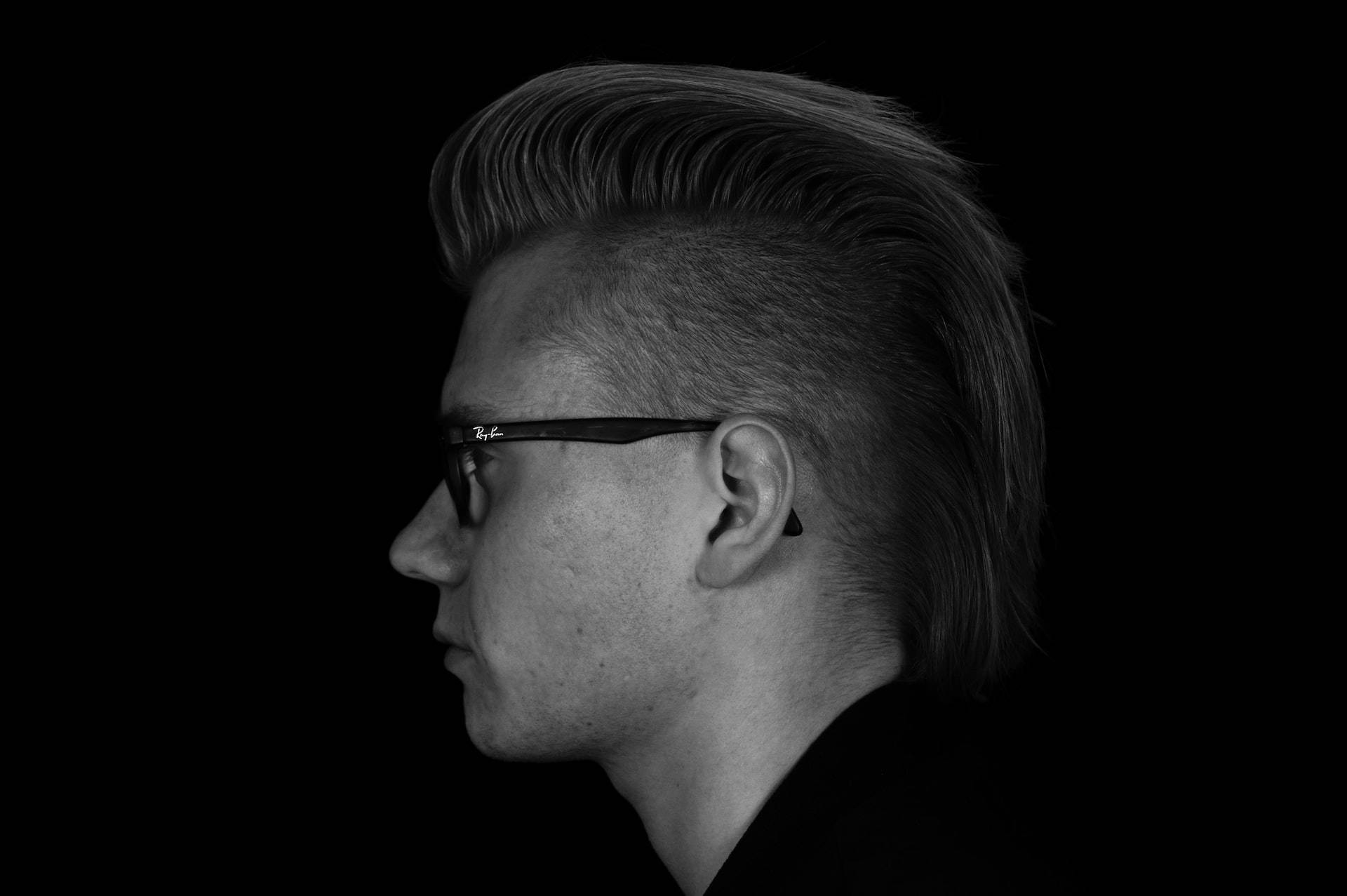 Haircut 桌布 壁紙 — 一個黑白側面肖像，一個男人梳著蓬巴杜髮型，戴著眼鏡，背景深色。