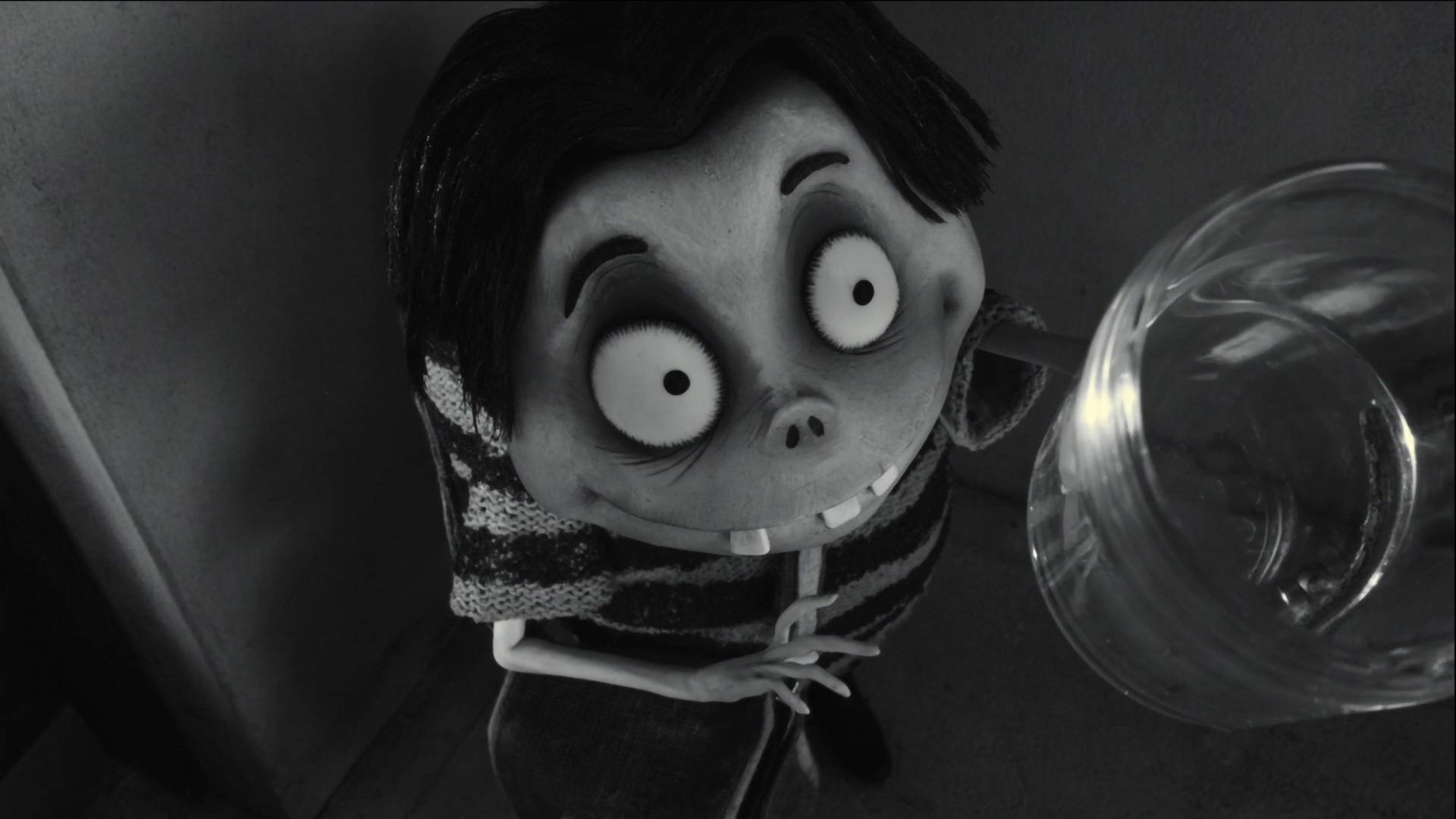 Frankenweenie 桌布 壁紙 — 一個黑白動畫角色，大眼睛，穿著條紋毛衣，在昏暗的角落裡拿著一個玻璃杯。