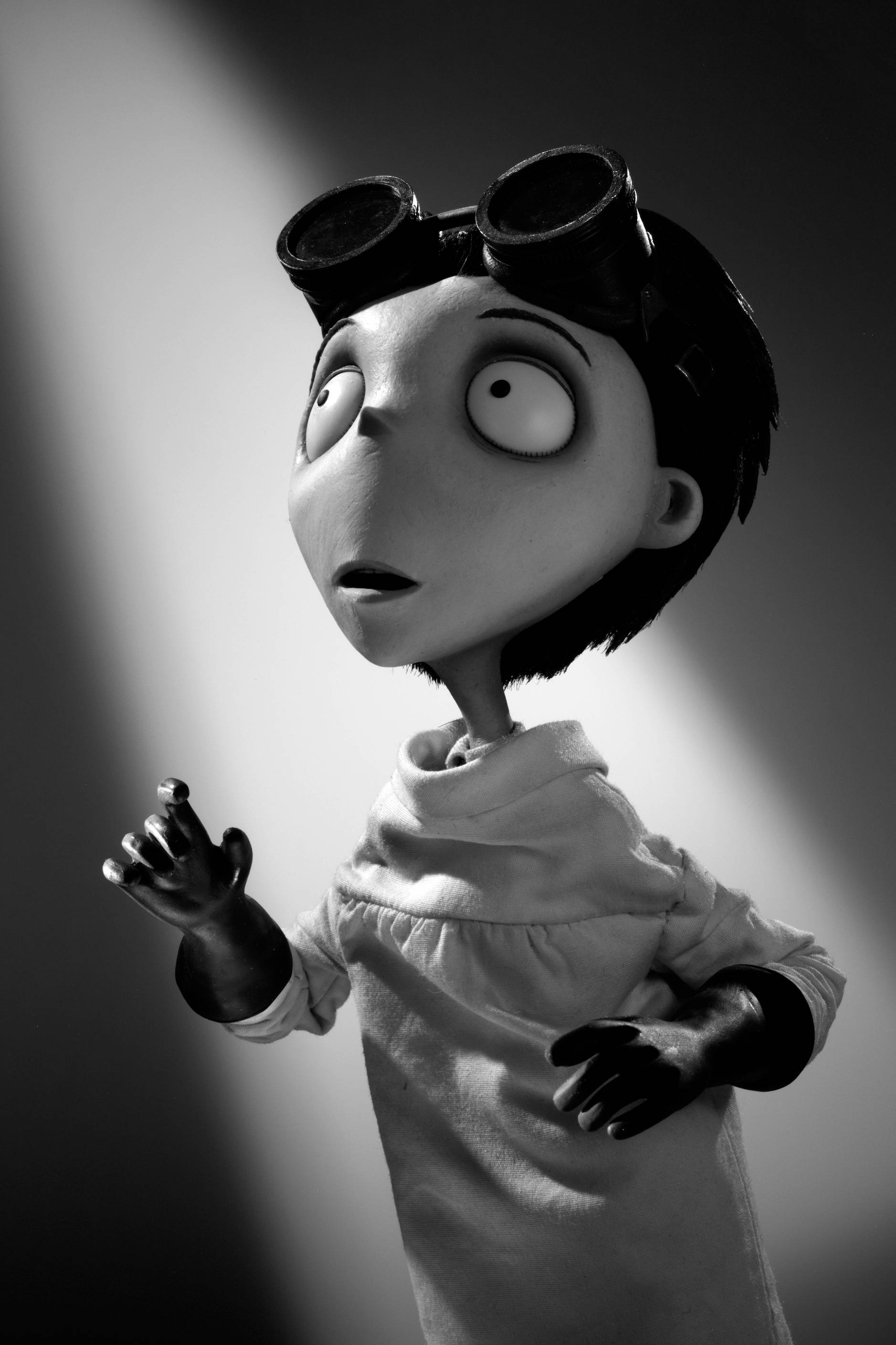 Frankenweenie 桌布 壁紙 — 一個黑白動畫角色，頭戴護目鏡，眼睛睜大，在聚光燈下顯得驚訝。