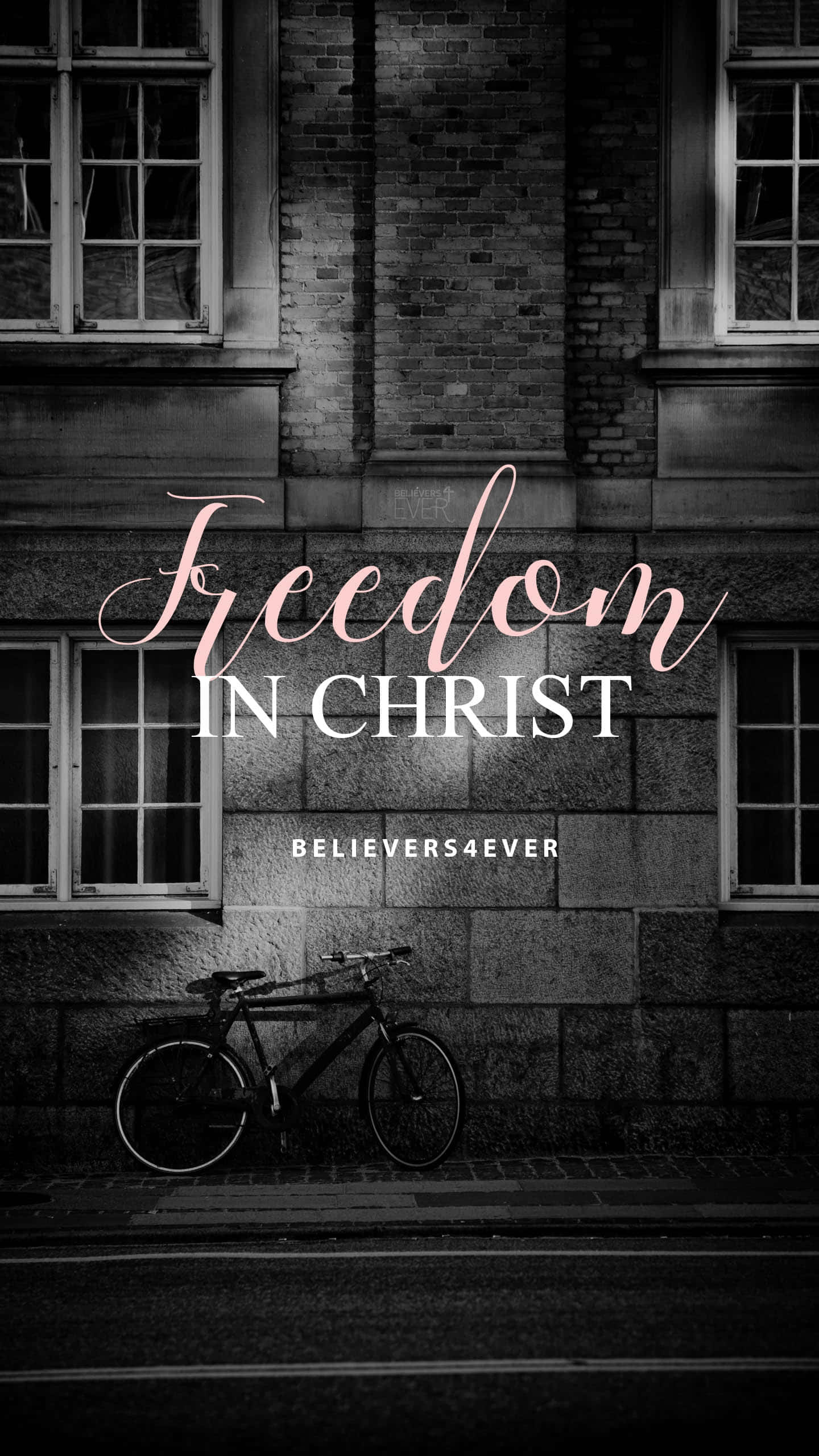 Freedom 桌布 壁紙 — 一個黑白城市場景，一輛腳踏車靠在一棟磚砌建築上，上面覆蓋著粉紅色和白色的勵志文字。