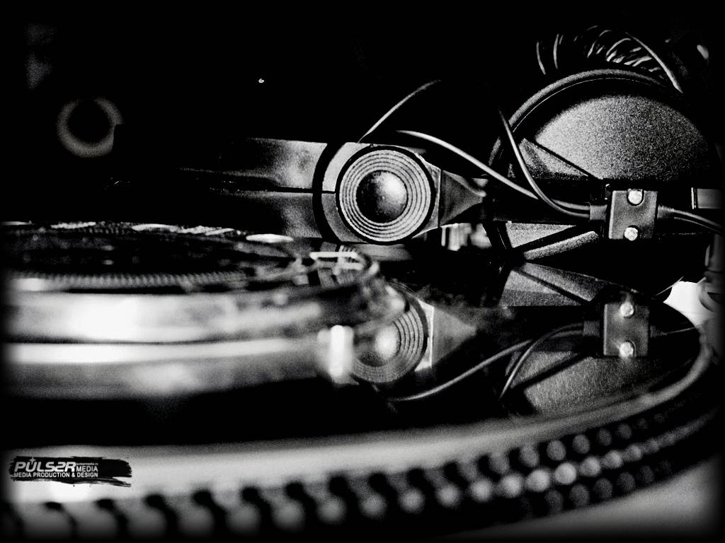 DJ 桌布 壁紙 — 一個黑白特寫，DJ 唱盤和耳機，電纜纏繞在粗糙的城市音樂工作室環境中。