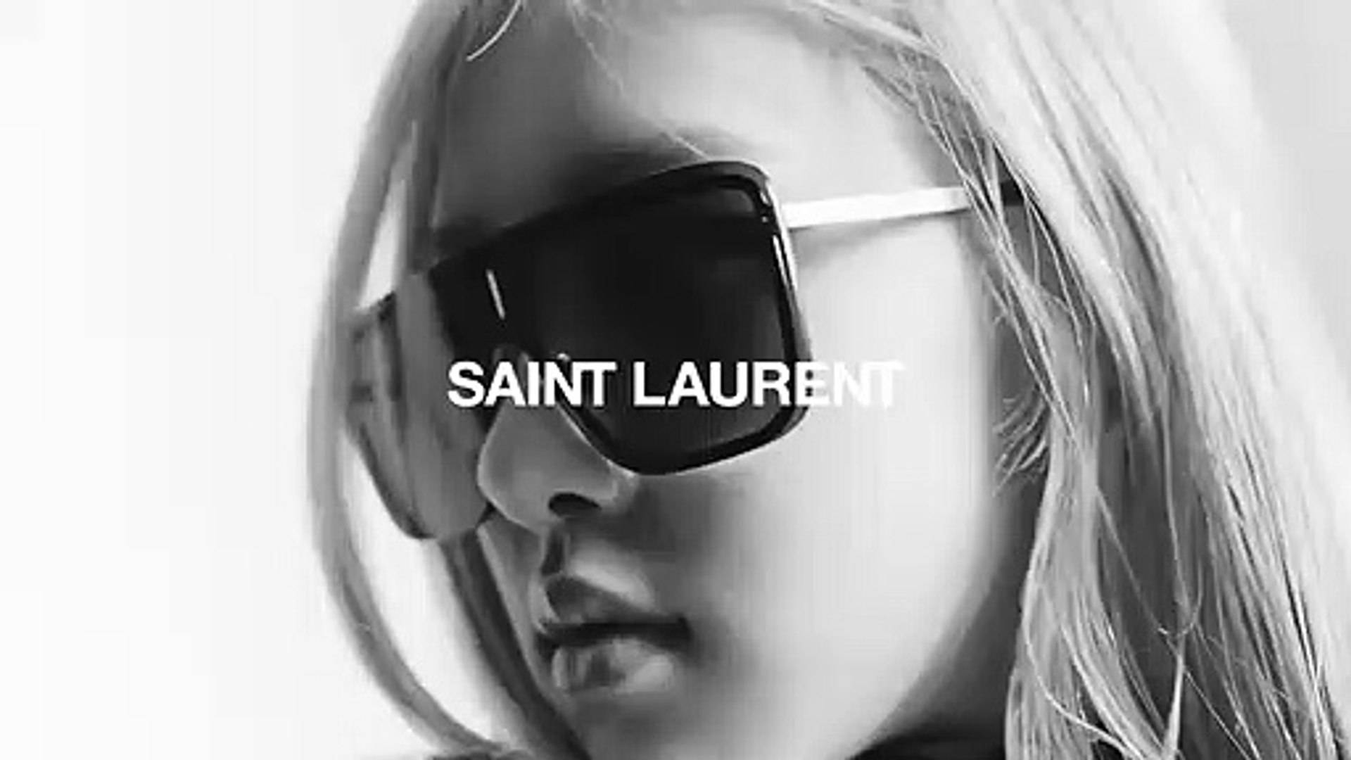 Sunglasses 桌布 壁紙 — 一個黑白特寫，一位金髮女性戴著超大太陽眼鏡，上面疊加著'SAINT LAURENT'文字。