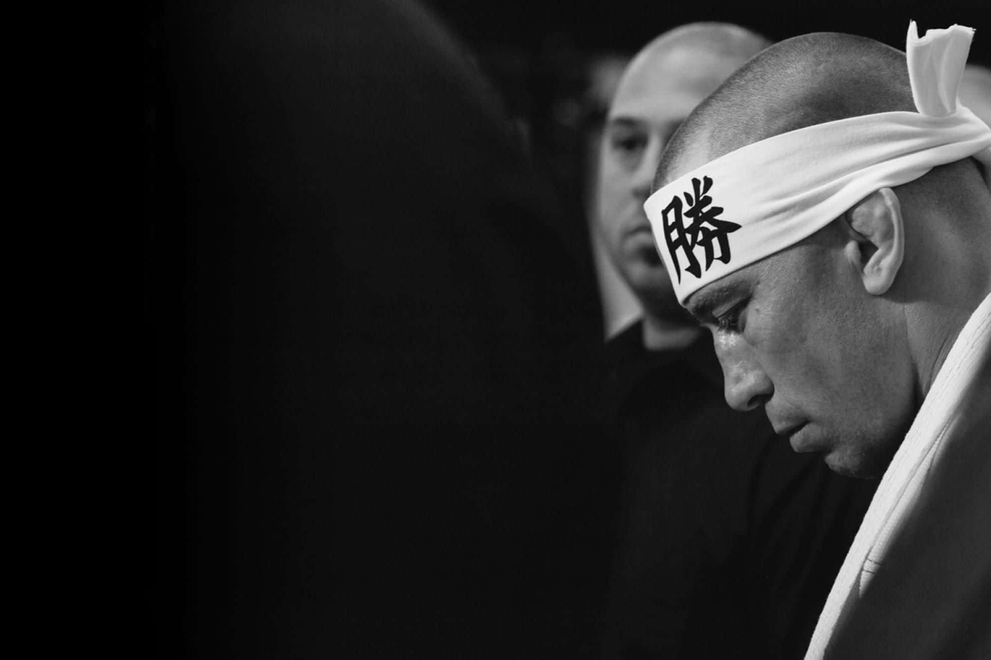 UFC 桌布 壁紙 — 一個黑白特寫，專注的相撲力士戴著漢字頭帶，眼睛低垂，神情肅穆專注。