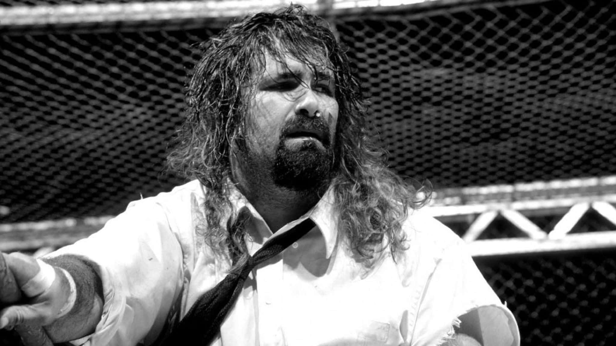 WWE 桌布 壁紙 — 一個黑白特寫，展示一位留長髮、鬍鬚的摔角手，身處被鐵絲網圍繞的擂台上。