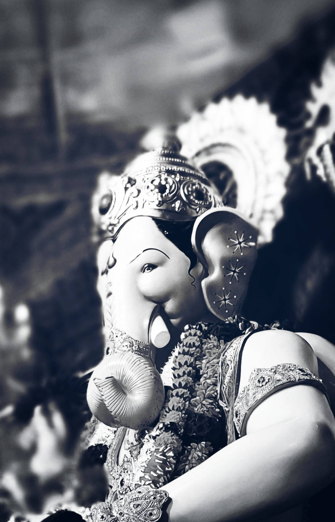 Ganesh 桌布 壁紙 — 一個黑白特寫，展示一尊裝飾華麗的象頭神雕像，飾有精緻珠寶和花環。