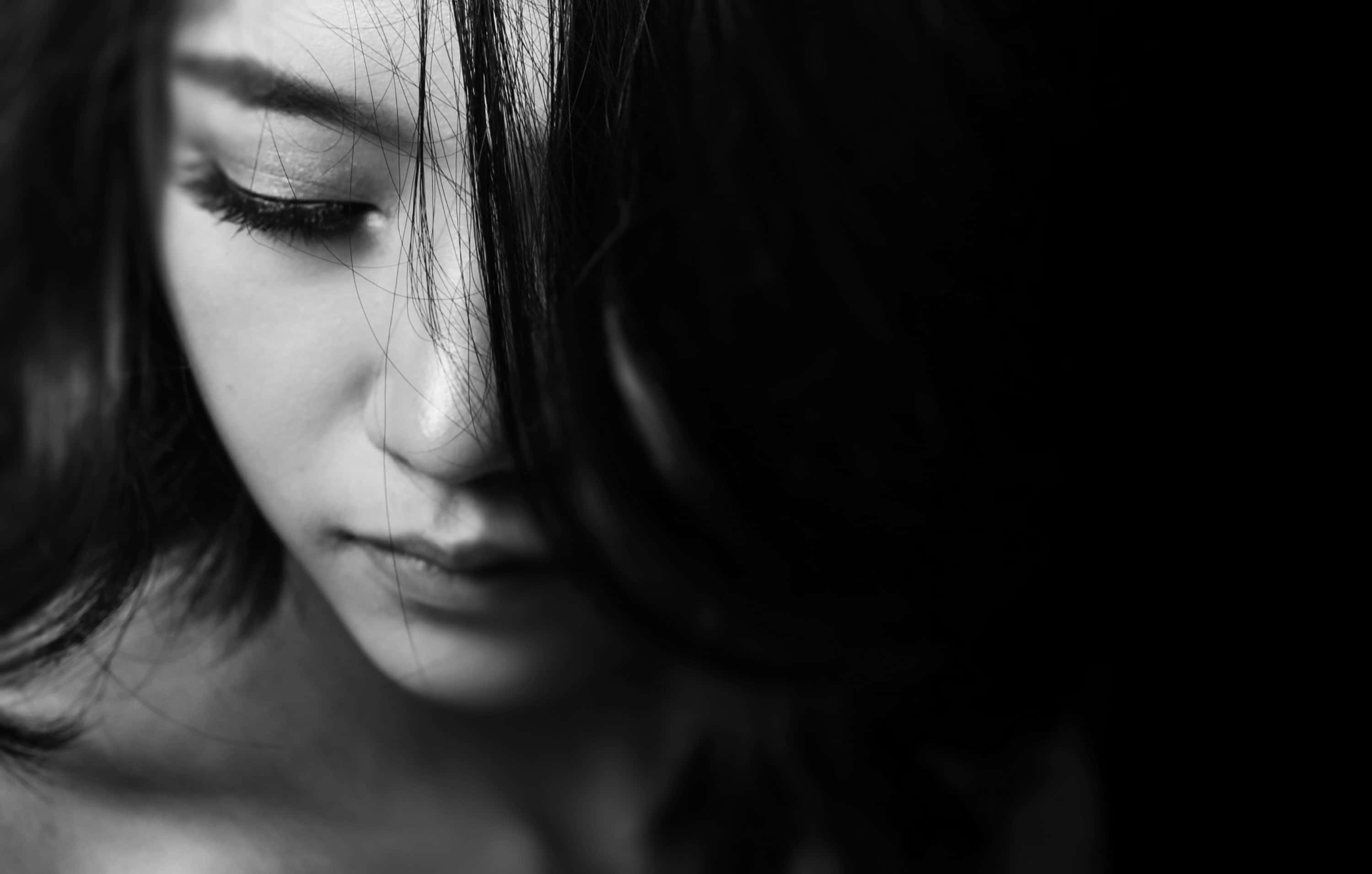 黑白 桌布 壁紙 — 一個黑白特寫，拍攝陰影中女性的臉部，雙眼閉合，頭髮部分遮蓋她的五官。