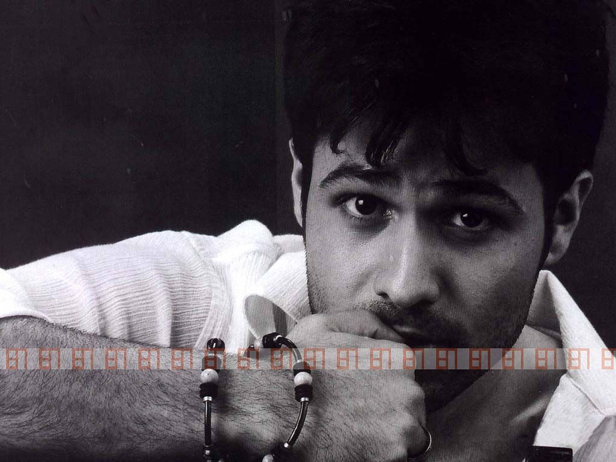Emraan Hashmi 桌布 壁紙 — 一個黑白特寫肖像，一個眼神凌厲的男人，托著下巴，穿著白色襯衫和珠子手鍊。