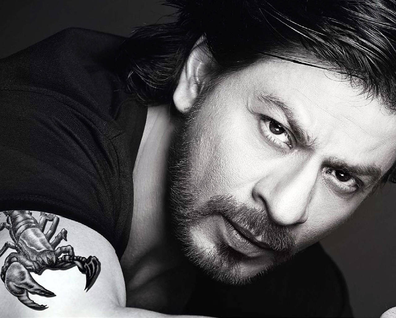 Shahrukh 桌布 壁紙 — 一個黑白特寫肖像，一個肩上紋有蠍子刺青的男人，正強烈地注視著鏡頭。