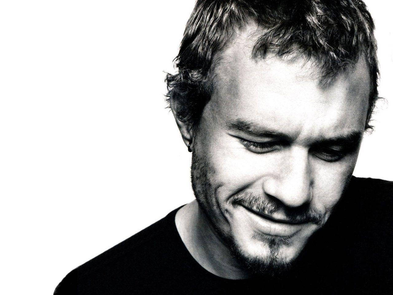 Heath Ledger 桌布 壁紙 — 一個黑白特寫肖像，一名男子帶著微妙微笑向下望，背景是純白色。