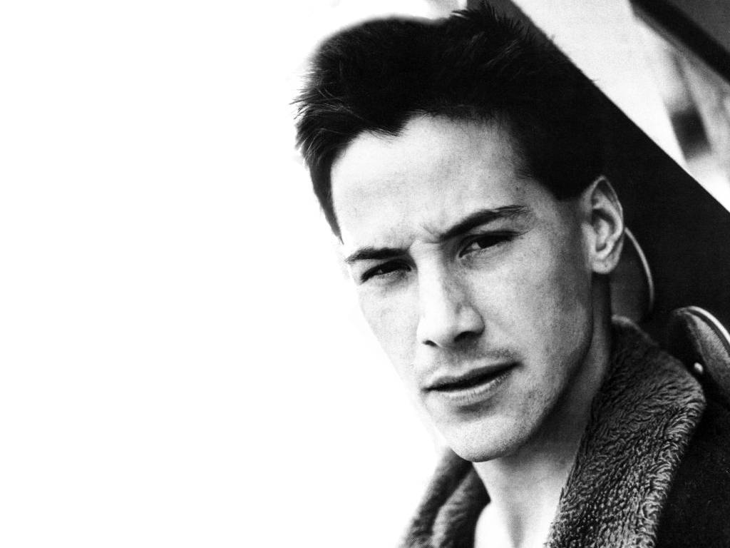 Keanu 桌布 壁紙 — 一個黑白特寫肖像，年輕男子眼神強烈，衣領有紋理，背景明亮。