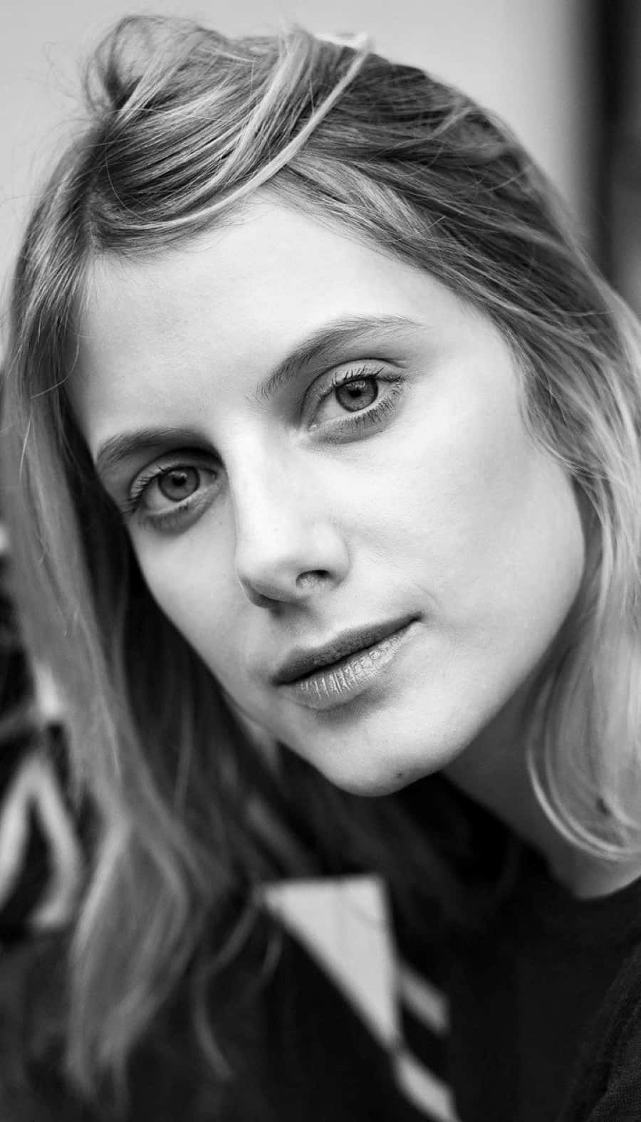 Mélanie Laurent 桌布 壁紙 — 一個黑白特寫肖像，捕捉一位頭髮柔軟、眼神銳利的女性，視線稍微偏離鏡頭。