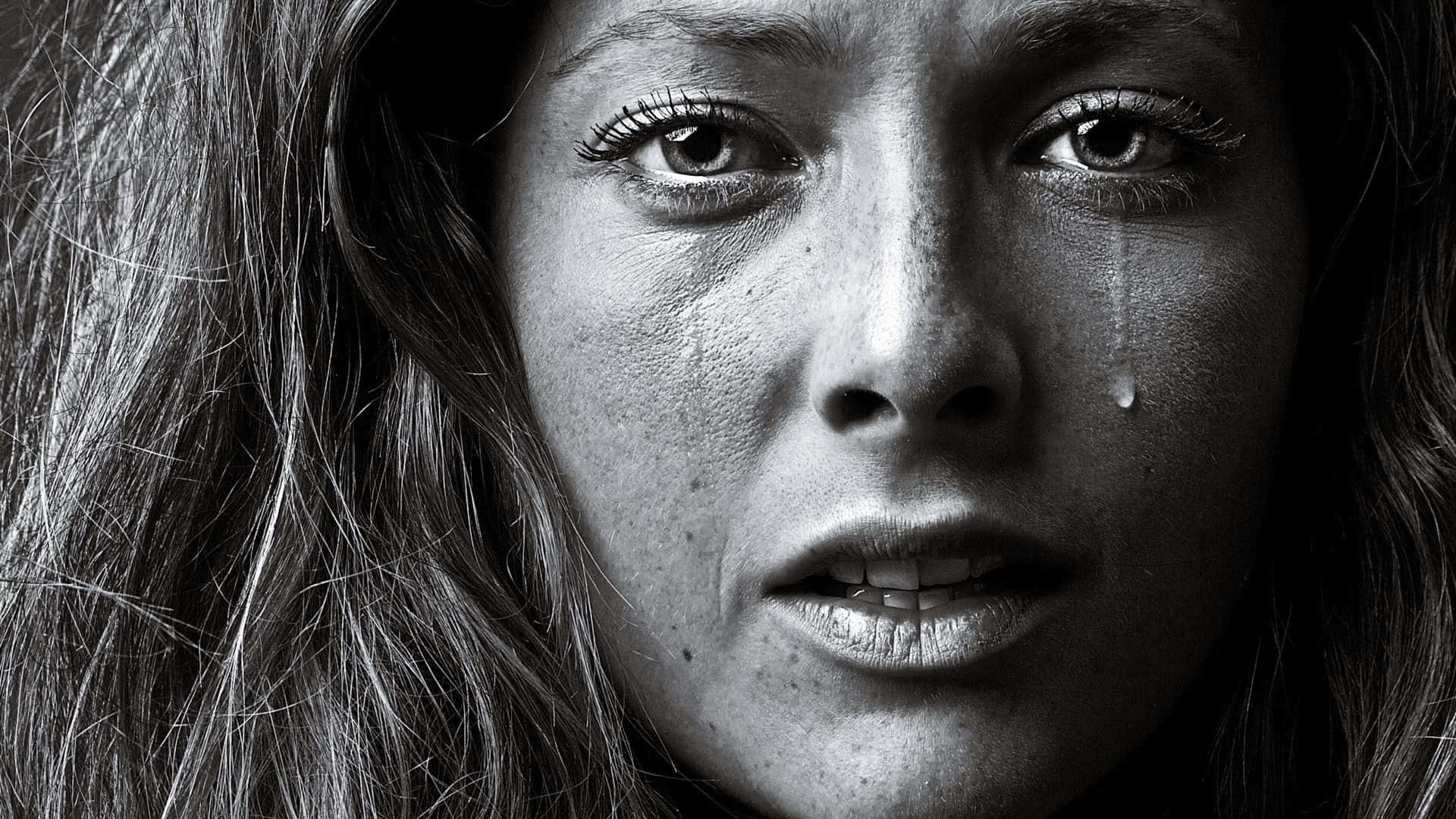cry 桌布 壁紙 — 一個黑白特寫鏡頭，捕捉到一位女性臉龐，淚珠沿著臉頰滑落，眼神充滿情感。