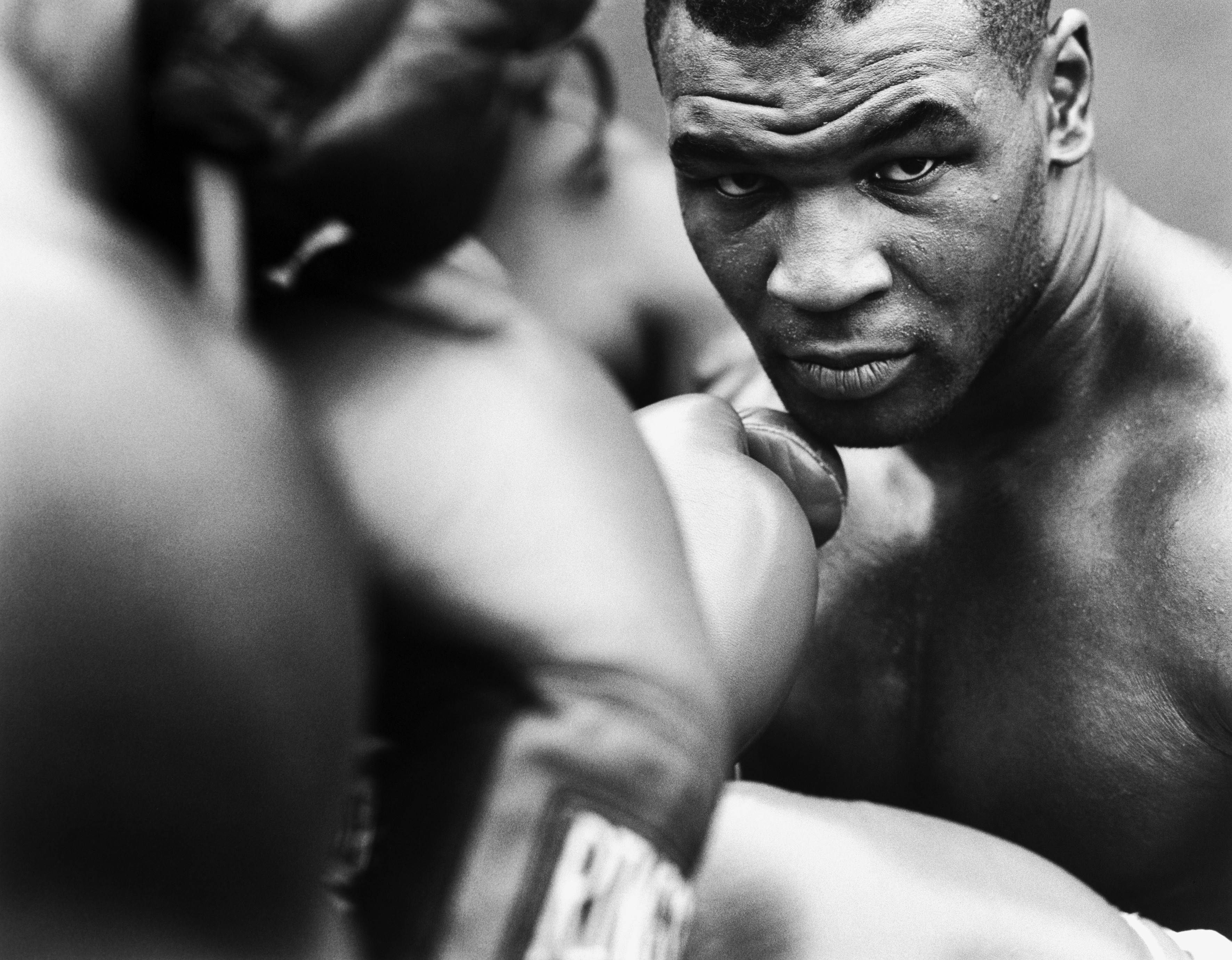 Boxing 桌布 壁紙 — 一個黑白特寫鏡頭，捕捉拳擊手在粗糙的擂台上，以強烈專注力凝視對手的瞬間。