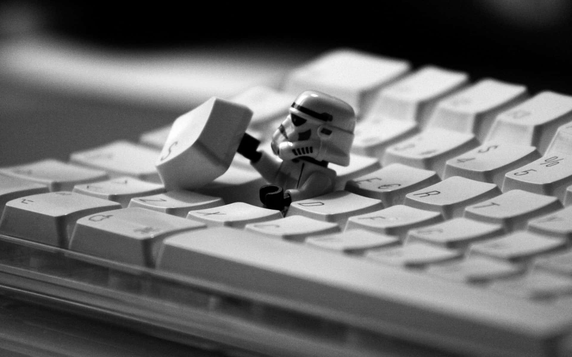 Funny Star Wars 桌布 壁紙 — 一個黑白特寫鏡頭，顯示一個LEGO風暴兵人偶在電腦鍵盤上拿著一個鍵盤鍵。