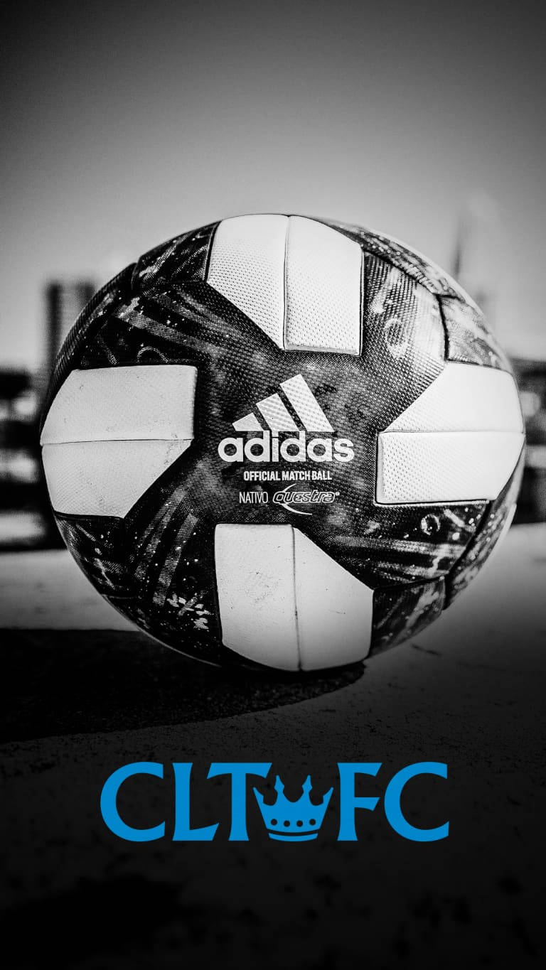 足球 桌布 壁紙 — 一個黑白相間的Adidas足球，上面有「CLTFC」標誌，放在路面上，背景是模糊的城市天際線。