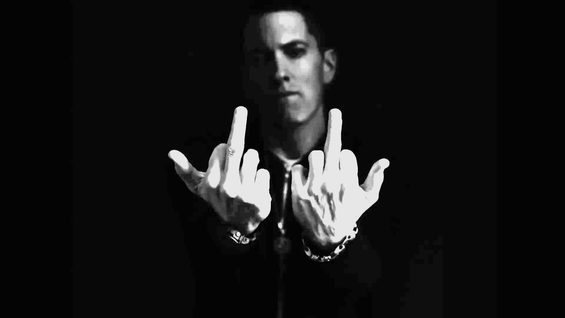 Eminem 桌布 壁紙 — 一個黑白相間的男人，雙手舉起，豎起中指，在黑暗背景下凝視鏡頭。
