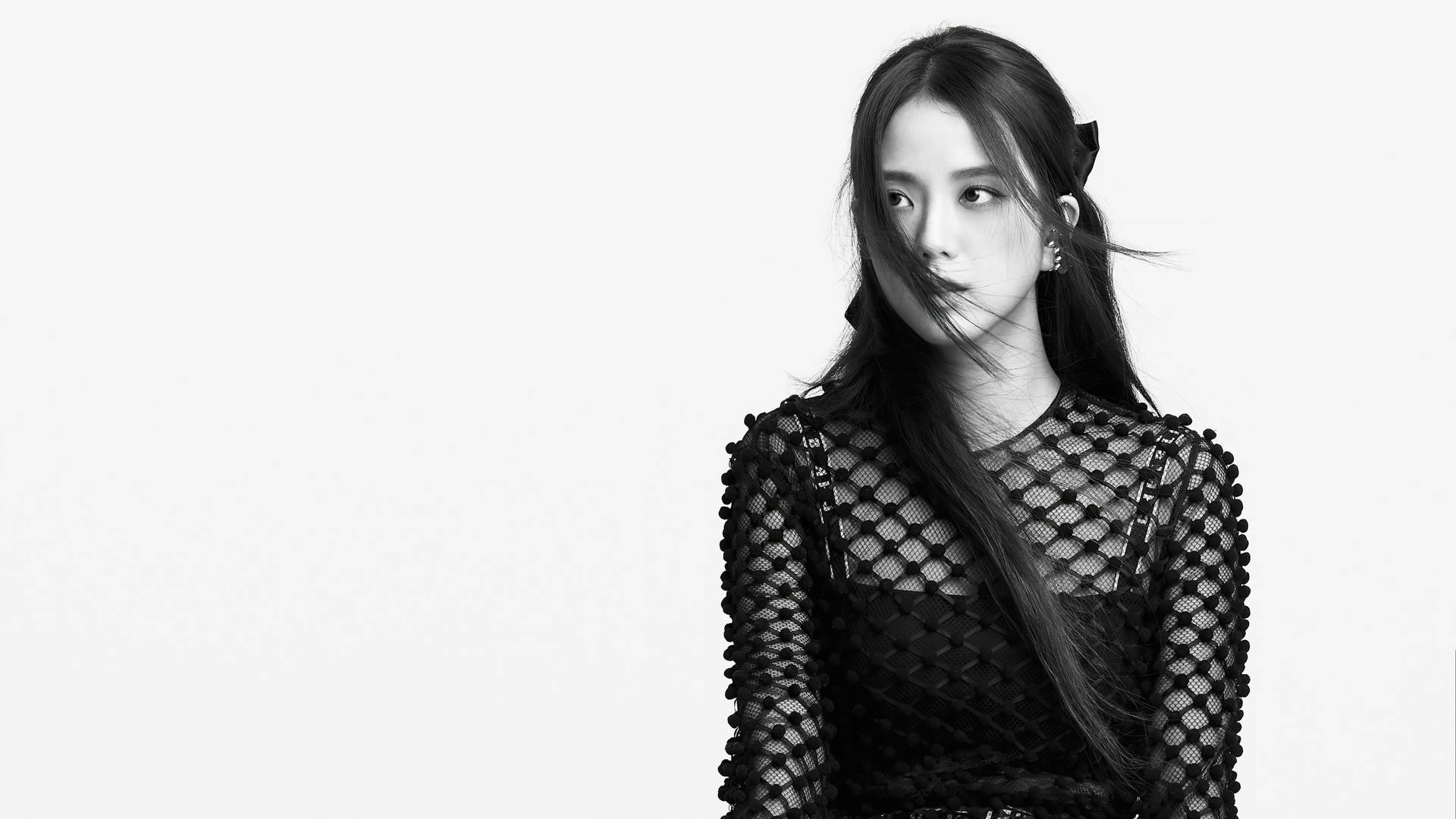 穿著黑色魚網上衣、頭髮被風吹拂的女性在工作室肖像中。 — 智秀 GIF 壁紙