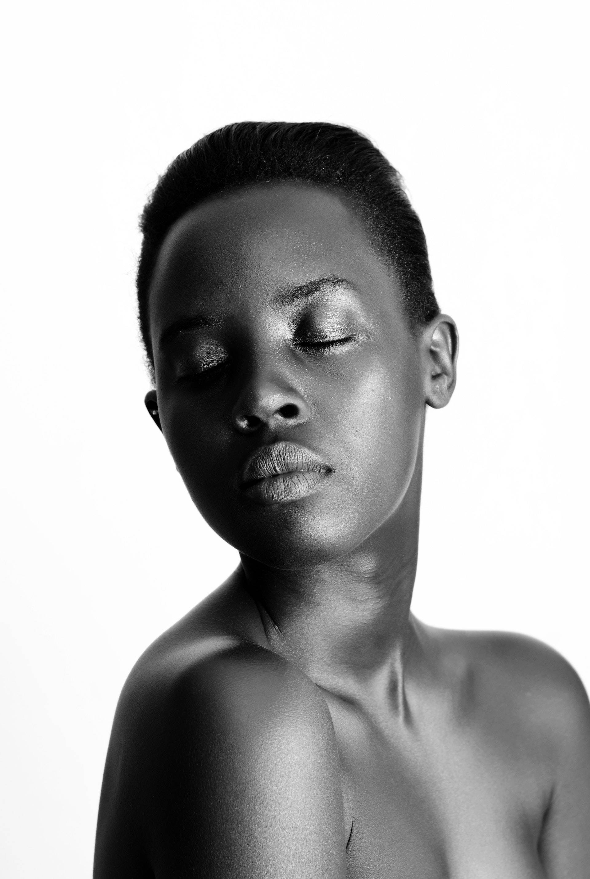 Black Girl 桌布 壁紙 — 一個黑白肖像，一位閉著眼睛、短髮的女性，背景是純白色。
