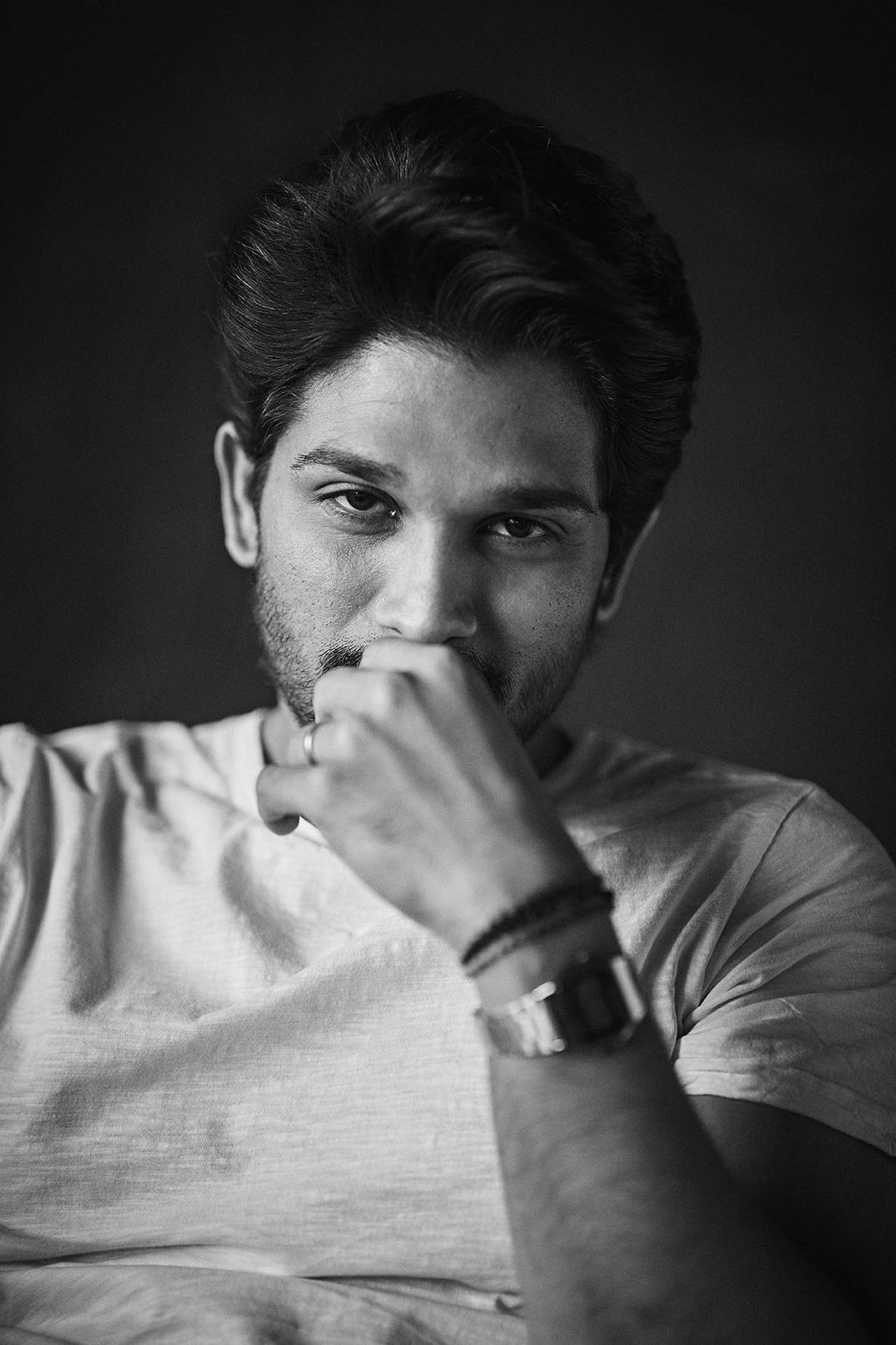 Allu Arjun 桌布 壁紙 — 一個黑白肖像，一個表情深思的男人，手靠近嘴巴，穿著T恤和手錶。