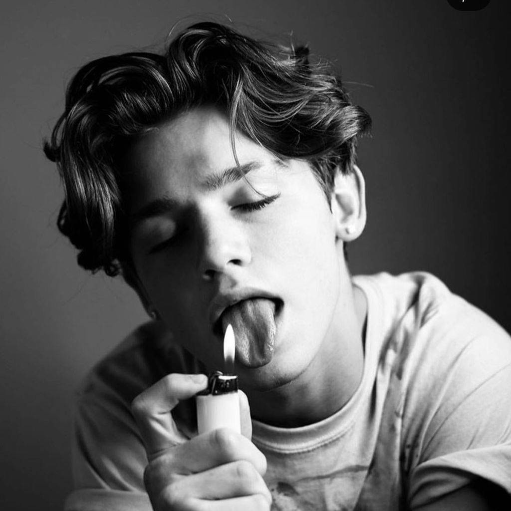 Payton 桌布 壁紙 — 一個黑白肖像，一個頭髮蓬鬆的年輕男子拿著點燃的打火機放在舌頭上。