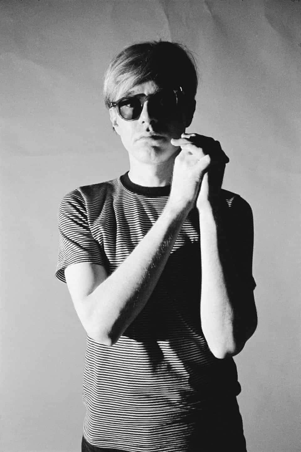 andy warhol 桌布 壁紙 — 一個黑白肖像，一名戴太陽眼鏡和條紋襯衫的男子在純色背景前拿著香煙。