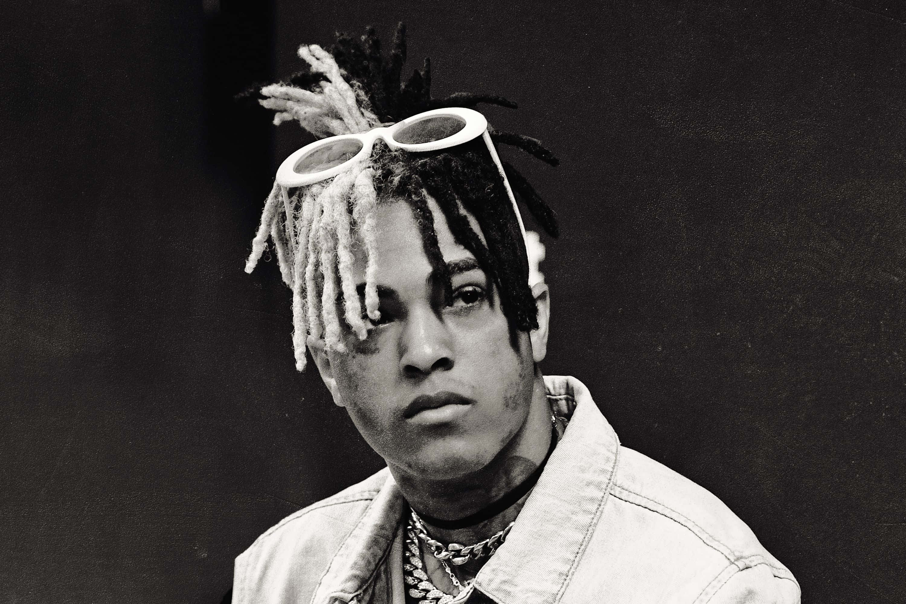 XXXTENTACION 桌布 壁紙 — 一個黑白肖像，一名男子留著辮子，頭戴白色邊框眼鏡，身穿牛仔外套和鏈條。