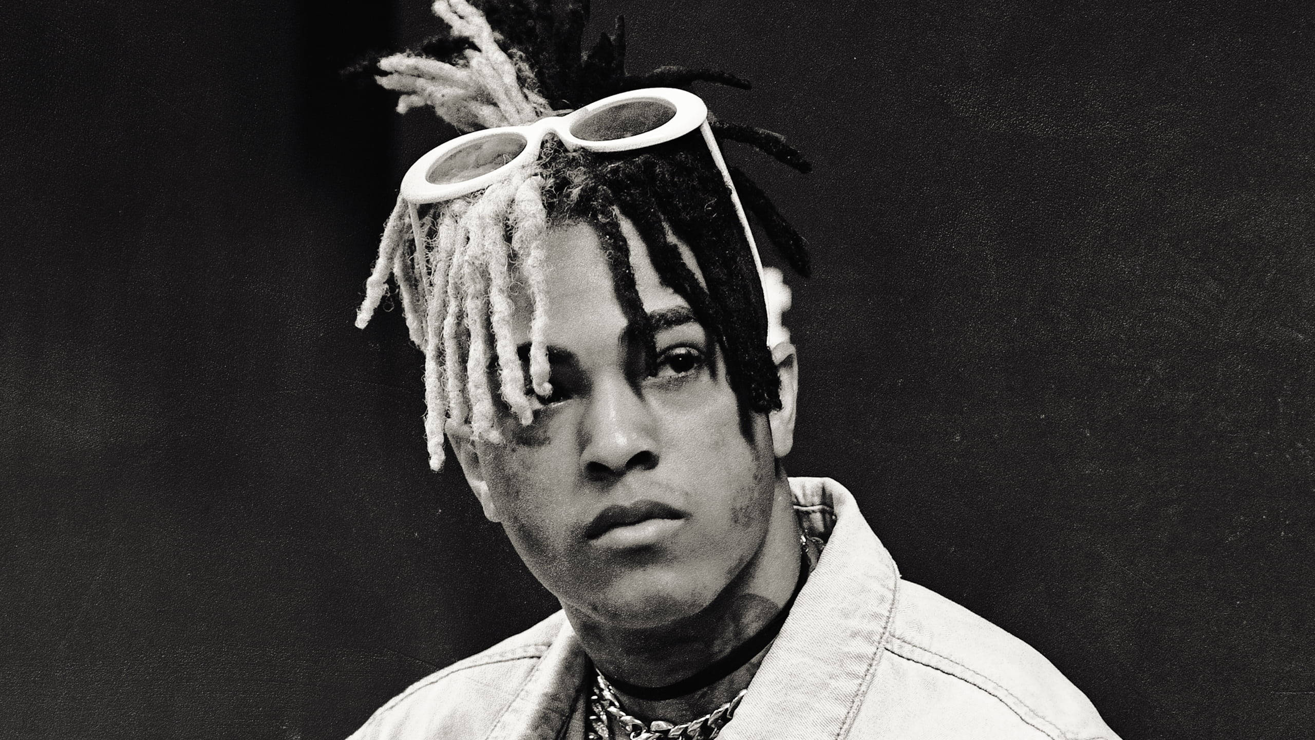 xxxtentacion 電腦 桌布 壁紙 — 一個黑白肖像，年輕男子留著辮子，白色太陽眼鏡擱在頭上，凝視鏡頭。