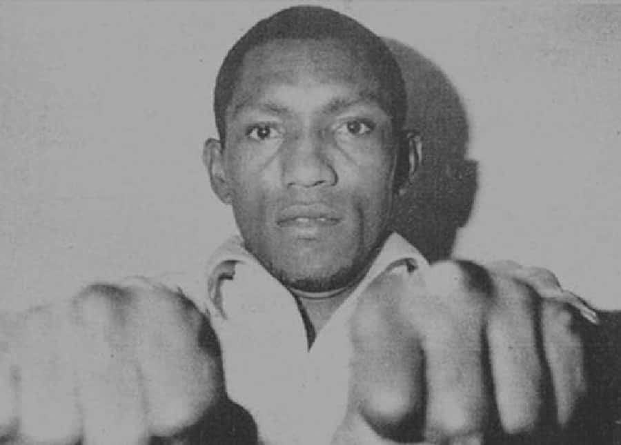 Boxing 桌布 壁紙 — 一個黑白肖像，拳擊手以戰鬥姿勢舉起拳頭，專注地向前凝視。