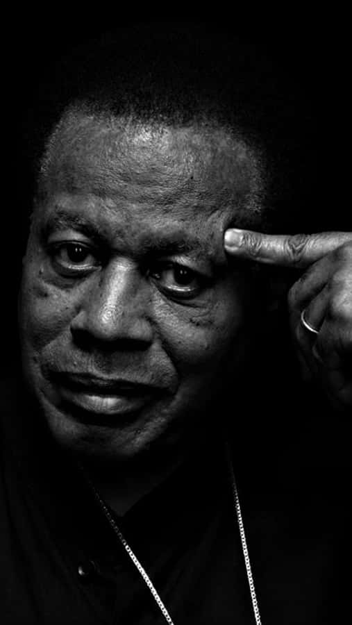 Wayne Shorter 桌布 壁紙 — 一個黑白肖像，男人手指放在太陽穴上，直視鏡頭。
