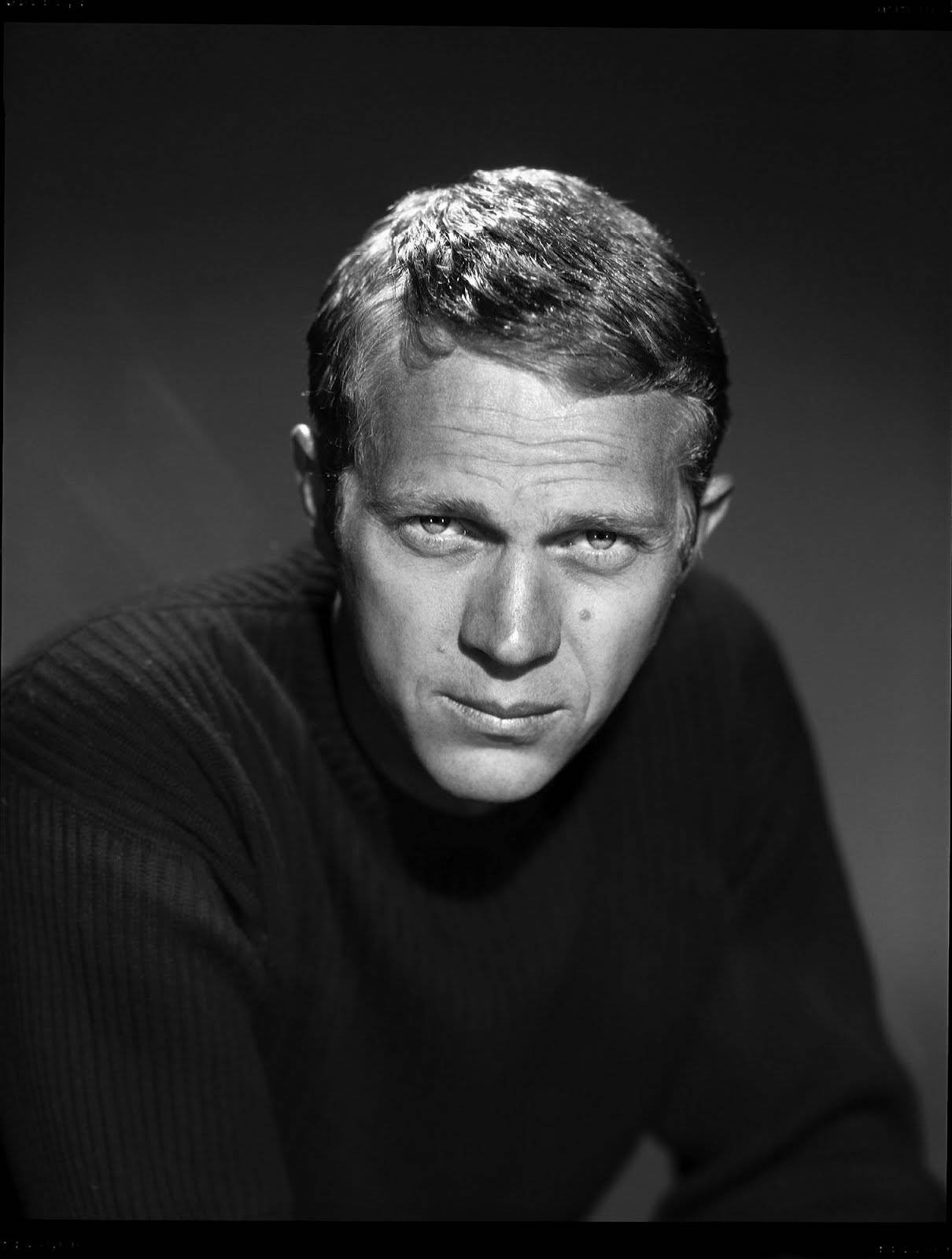 actor 桌布 壁紙 — 一個黑白肖像，男人眼神銳利，穿著質感毛衣，背景為深色漸變。