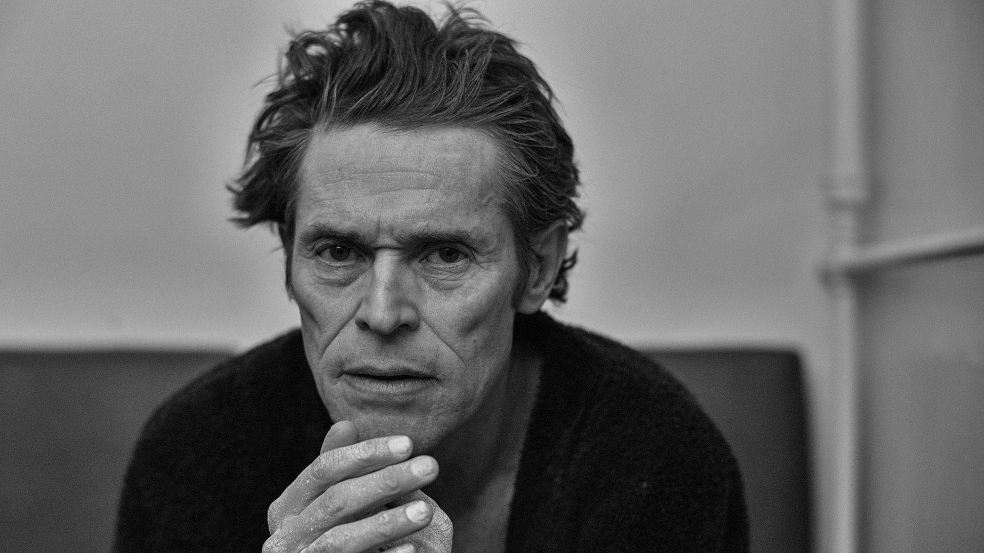 Willem Dafoe 桌布 壁紙 — 一個黑白肖像，男人眼神銳利，頭髮凌亂，手托下巴。