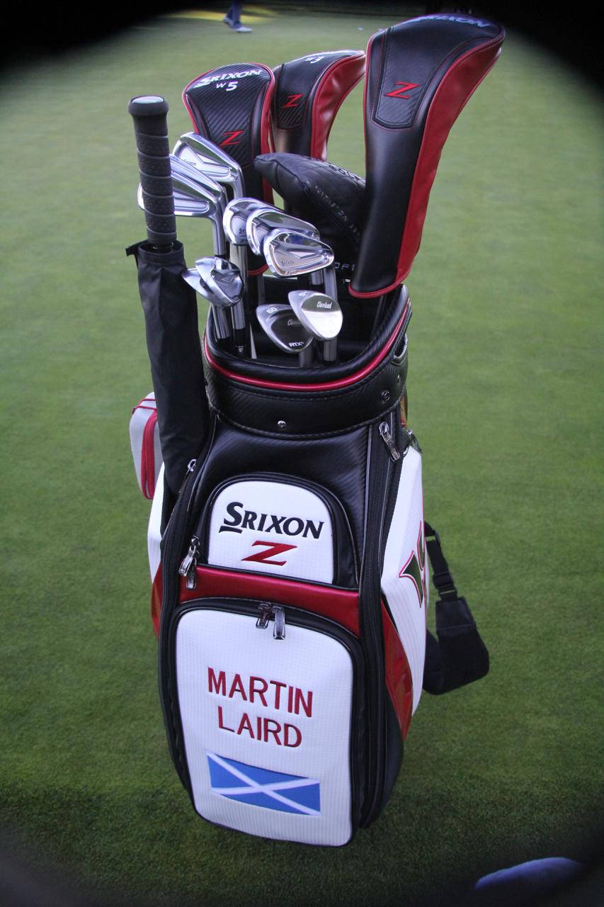 桌布 壁紙 — 一個黑色、紅色和白色的Srixon高爾夫球袋，上面有Martin Laird的名字和蘇格蘭國旗，立在翠綠的球道上。