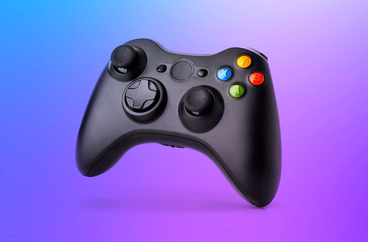 Xbox 桌布 壁紙 — 一個黑色Xbox手把漂浮在由藍到紫的漸變背景上，帶有柔和光線。