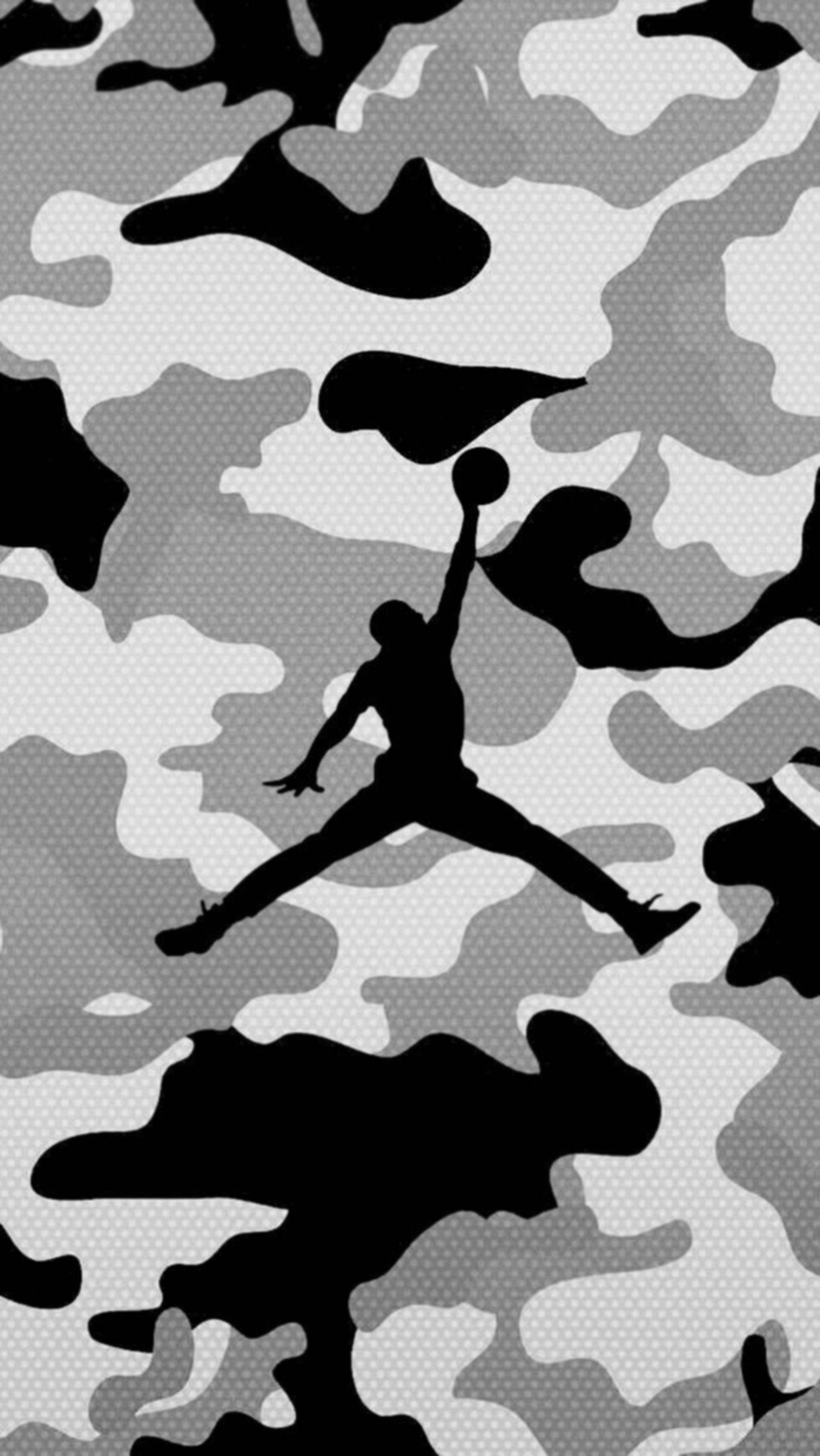 Air Jordan 桌布 壁紙 — 一個黑色剪影，描繪麥可喬丹在半空中灌籃籃球，背景為灰色和黑色迷彩圖案。